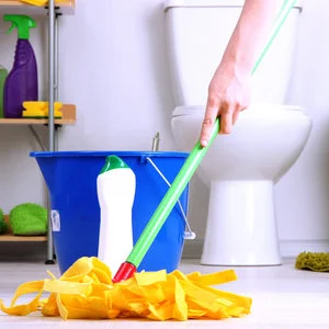 A maid is mopping a bathroom floor.