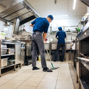 A maid is mopping the kitchen floor.