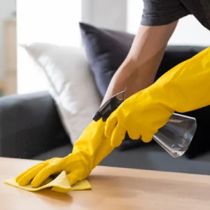 A maid is cleaning a coffee table.